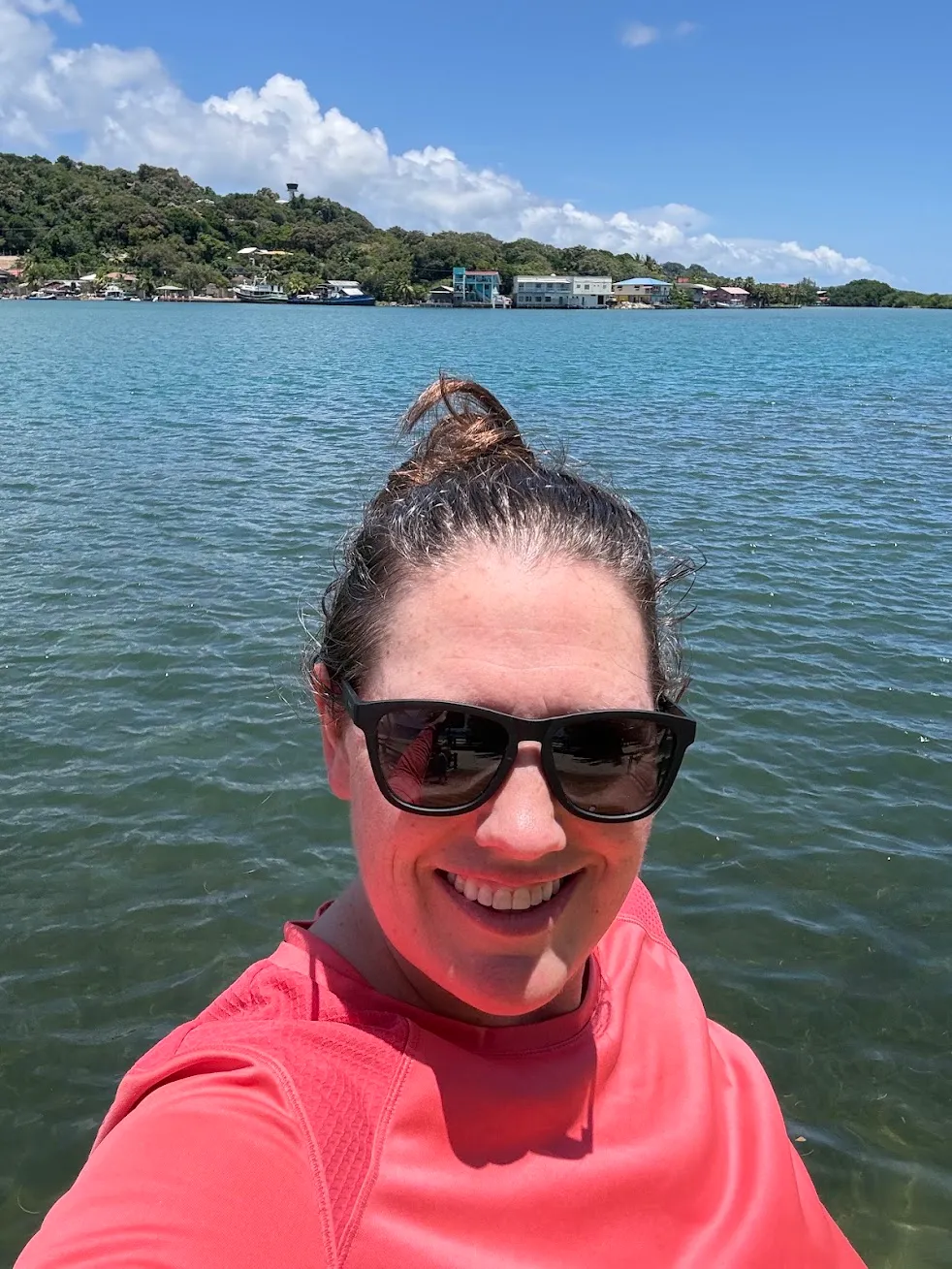 Kate smiling in sunglasses on the water