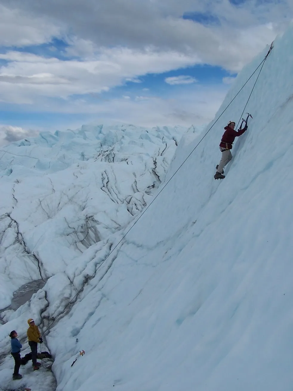 Kate ice climbing a glacier wall in Alaska