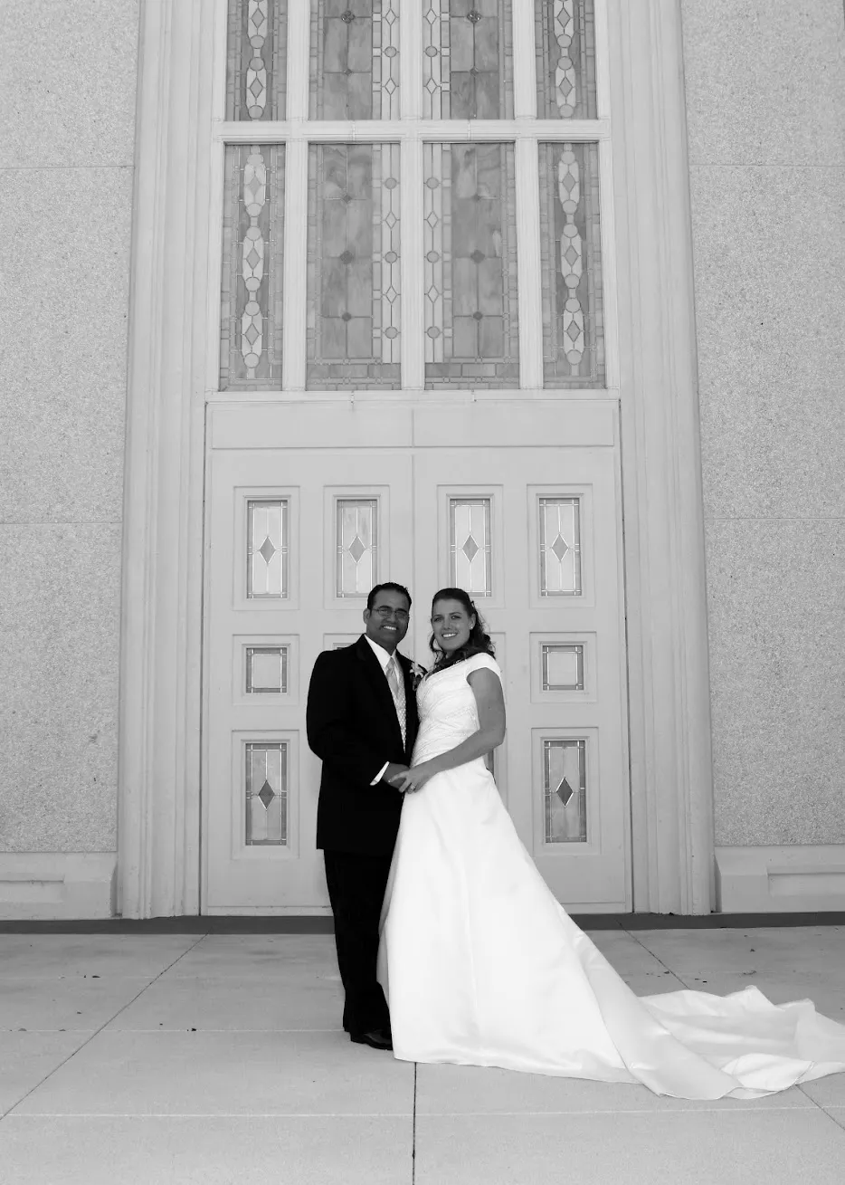 Black and white photo of Kate and Omar on their wedding day in front of the temple doors